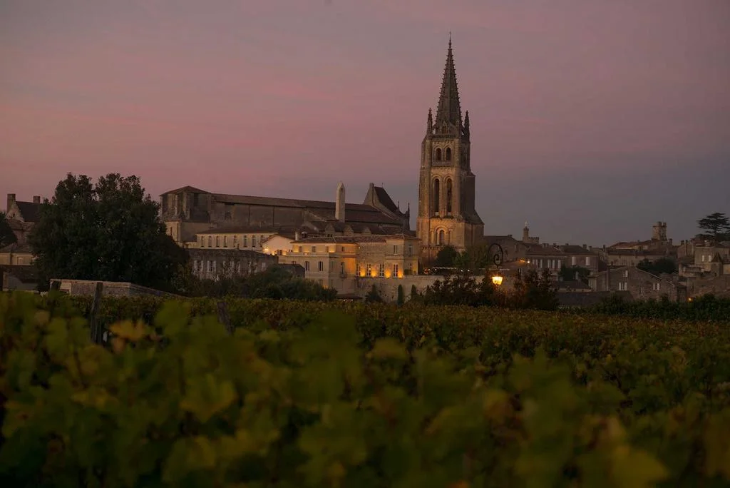 Saint-Émilion au crépuscule, son clocher éclairé et ses vignes